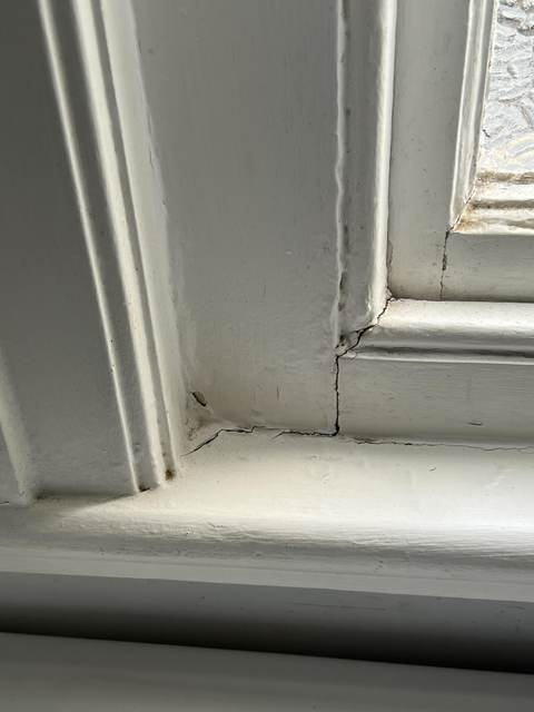 A painted-shut timber sash window with a failed sash cord